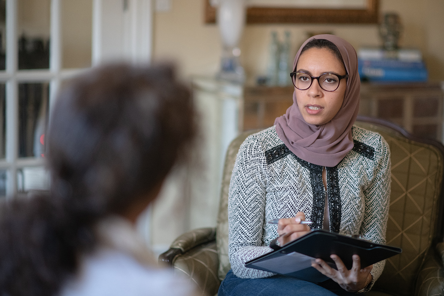 a therapist and client sitting in chairs, having a conversation